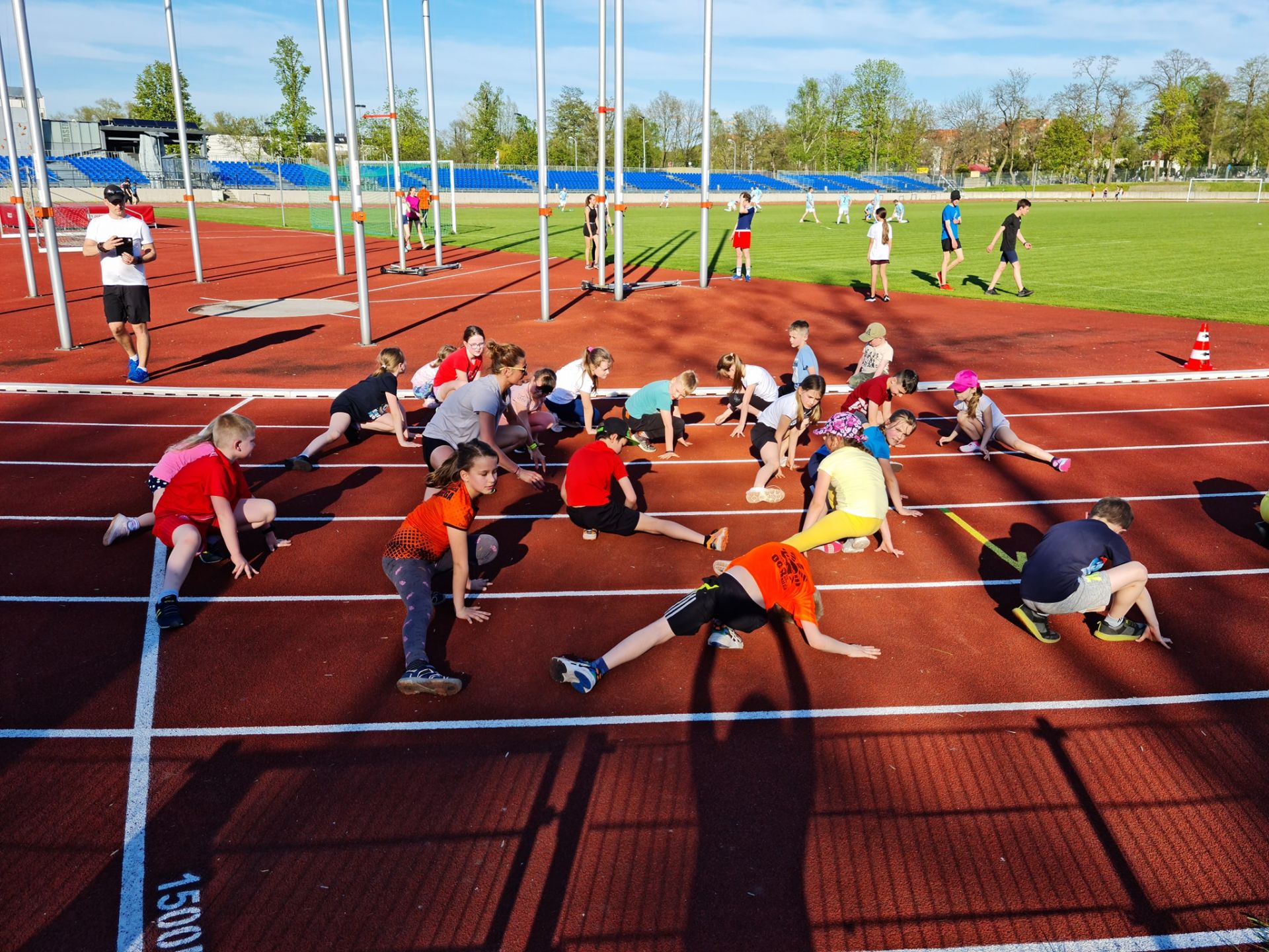 dzieci ćwiczące na stadionie miejskim